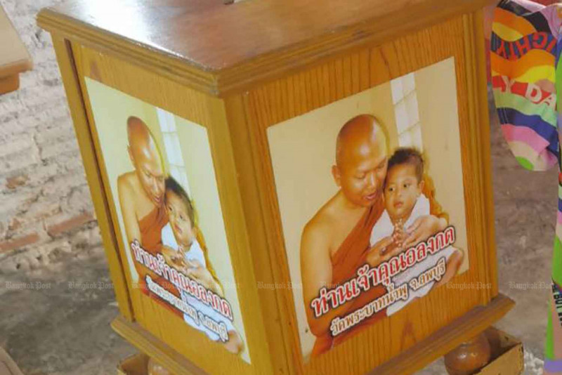 A donation box with pictures of Phra Alongkot, the abbot of Wat Phra Bat Nam Phu in Lop Buri, is seen at a fresh market in Bangkok last month.