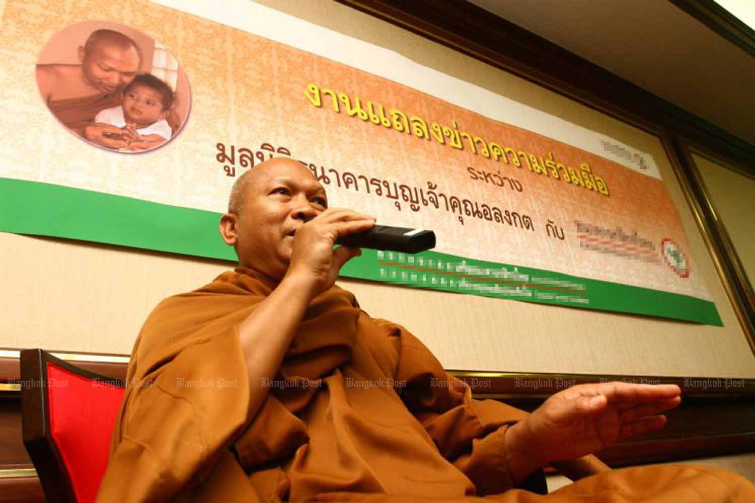 In 2007, the then-abbot of Wat Phrabatnampu, Phra Khru Alongkot Dikkapanyo, makes a point at a press conference urging people to donate money to the hospice temple's fund. (Photo: Bangkok Post)