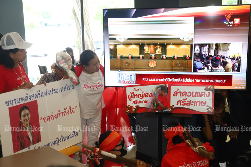 Supporters of suspended prime minister Paetongtarn Shinawatra watch a monitor showing proceedings at the Constitutional Court, at the Pheu Thai Party headquarters in Bangkok on Friday. (Photo: Nutthawat Wichieanbut)