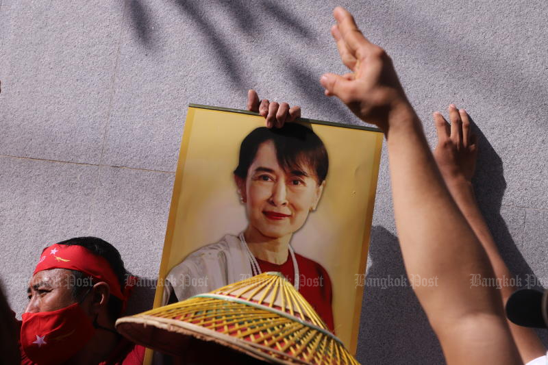 Myanmar migrant workers show a picture of their leader, Aung San Suu Kyi, at a gathering in front of the Myanmar embassy in Bangkok to mark International Migrants Day, on Dec 18, 2022. (Photo: Pornprom Satrabhaya)