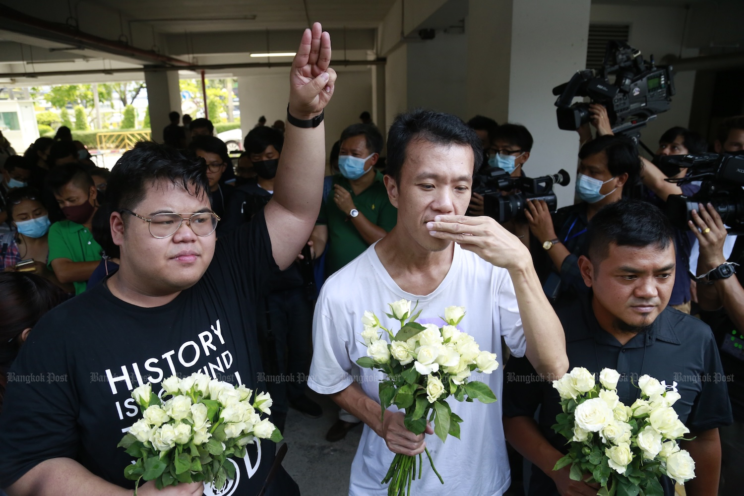 Three of the five people charged with endangering the Queen by blocking a royal motorcade arrive at the Office of the Attorney General to hear the charges, on March 31, 2021. From left: Bunkueanun “Francis” Paothong, Ekachai Hongkangwan and Suranat Panprasert. (Bangkok Post File Photo)