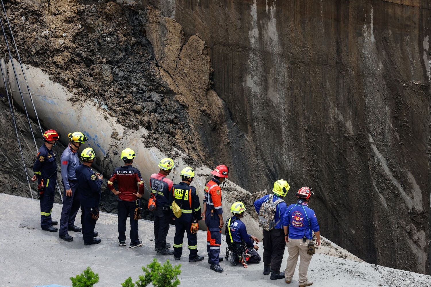Deep trouble: Engineers and inspectors take a closer look at the sinkhole, which is about 20 metres deep. (Photo: Bloomberg)  