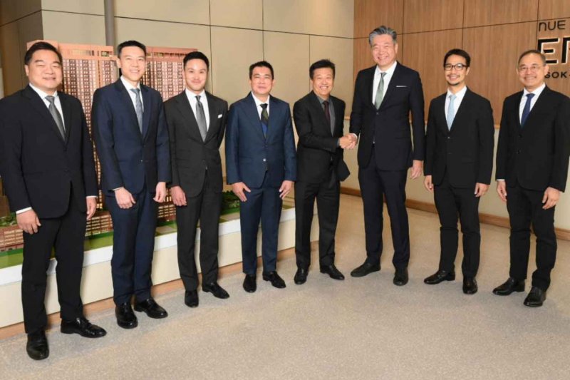 Mr Pakpoom (fourth from right) and Mr Thongchai (third from right), shake hands to symbolise their partnership in the 14-billion-baht joint venture condo project.
