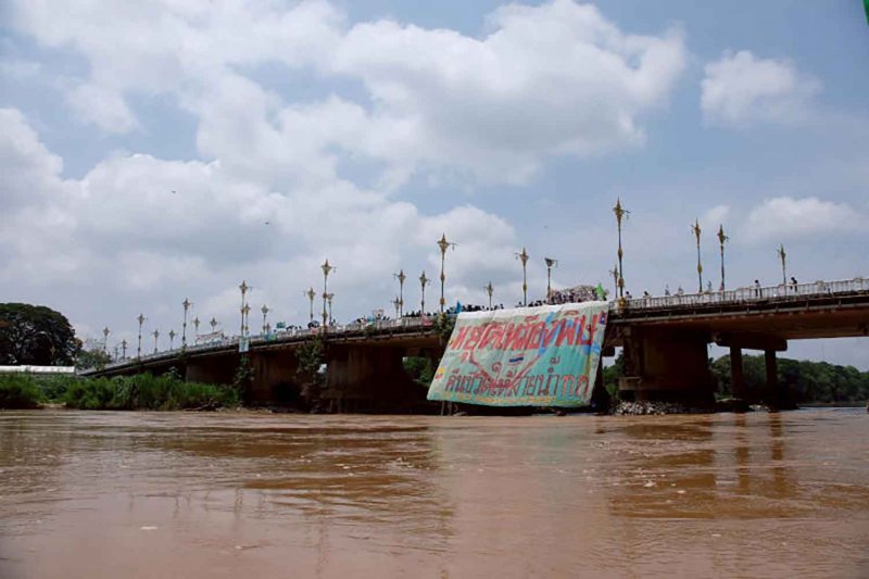 Residents affected by heavy metal pollution from unregulated mining operations in Myanmar rally at the Kok River Bridge in Chiang Rai in June, displaying a banner that reads ‘Stop the Toxic Mines, Return Lives to the Kok River’. Wassayos Ngamkham