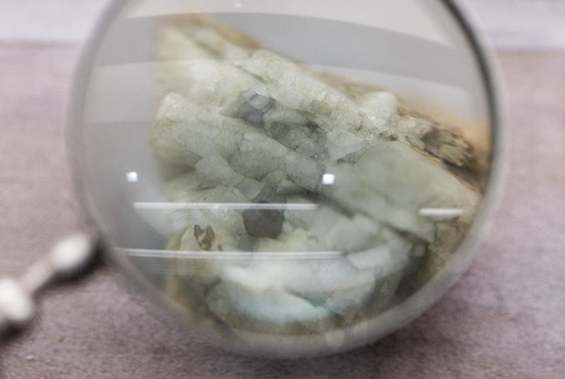 ตัวอย่างของโมนาไซต์ ซึ่งเป็นแร่ที่ใช้ในอุตสาหกรรมธาตุหายากเพื่อสกัดธาตุต่างๆ เช่น ซีเรียม แลนทานัม และนีโอไดเมียม ถูกจัดแสดงอยู่ข้างกระจกขยายที่พิพิธภัณฑ์ธรณีวิทยาของจีนในกรุงปักกิ่ง ประเทศจีน เมื่อวันที่ 14 ต.ค. 2568 (ภาพ: รอยเตอร์)