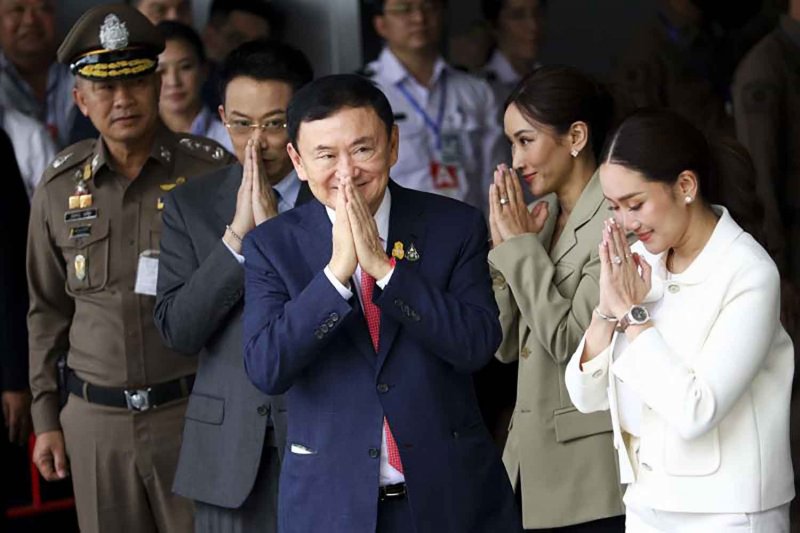 Thaksin Shinawatra and his son, Panthongtae, and daughters Pintongta and Paetongtarn, far right, perform ‘wais’ to supporters who turned up in droves to greet the former premier on his homecoming, at the Mjets terminal of Don Mueang Airport on Aug 22, 2023. Pattarapong Chatpattarasill