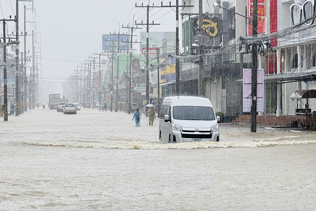 A van is driven along a flooded street in Muang district of Nakhon Si Thammarat on Friday after the city centre was inundated. (Photo: Nujaree Rakrun)