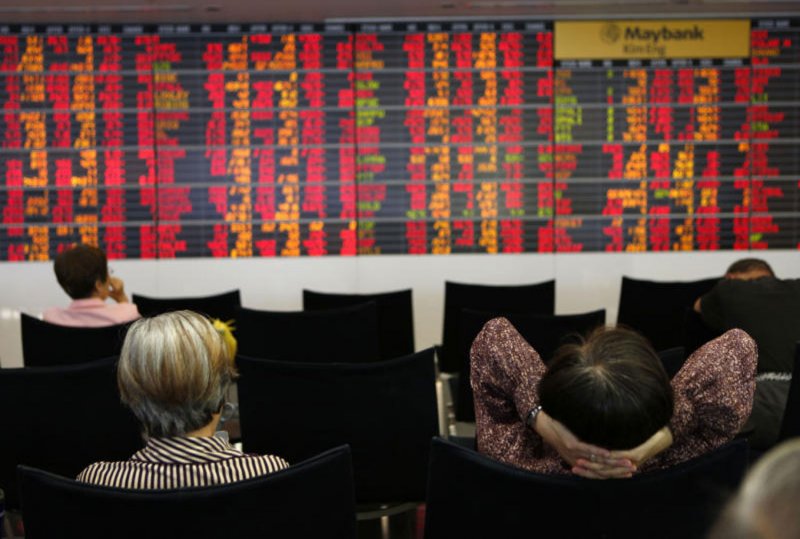 Investors study stock prices on an electronic board displaying indices at a stock brokerage house in Bangkok.(Photo: Pattarapong Chatpattarasill)
