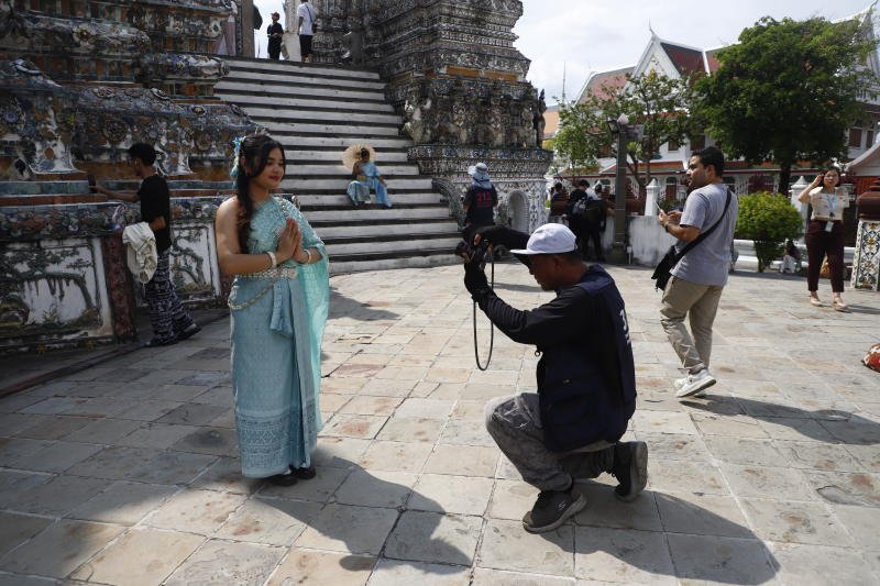 2025 年 10 月 9 日，一名游客在泰国曼谷的一座佛教寺庙里摆姿势拍照。（照片：Nutthawat Wichieanbut）