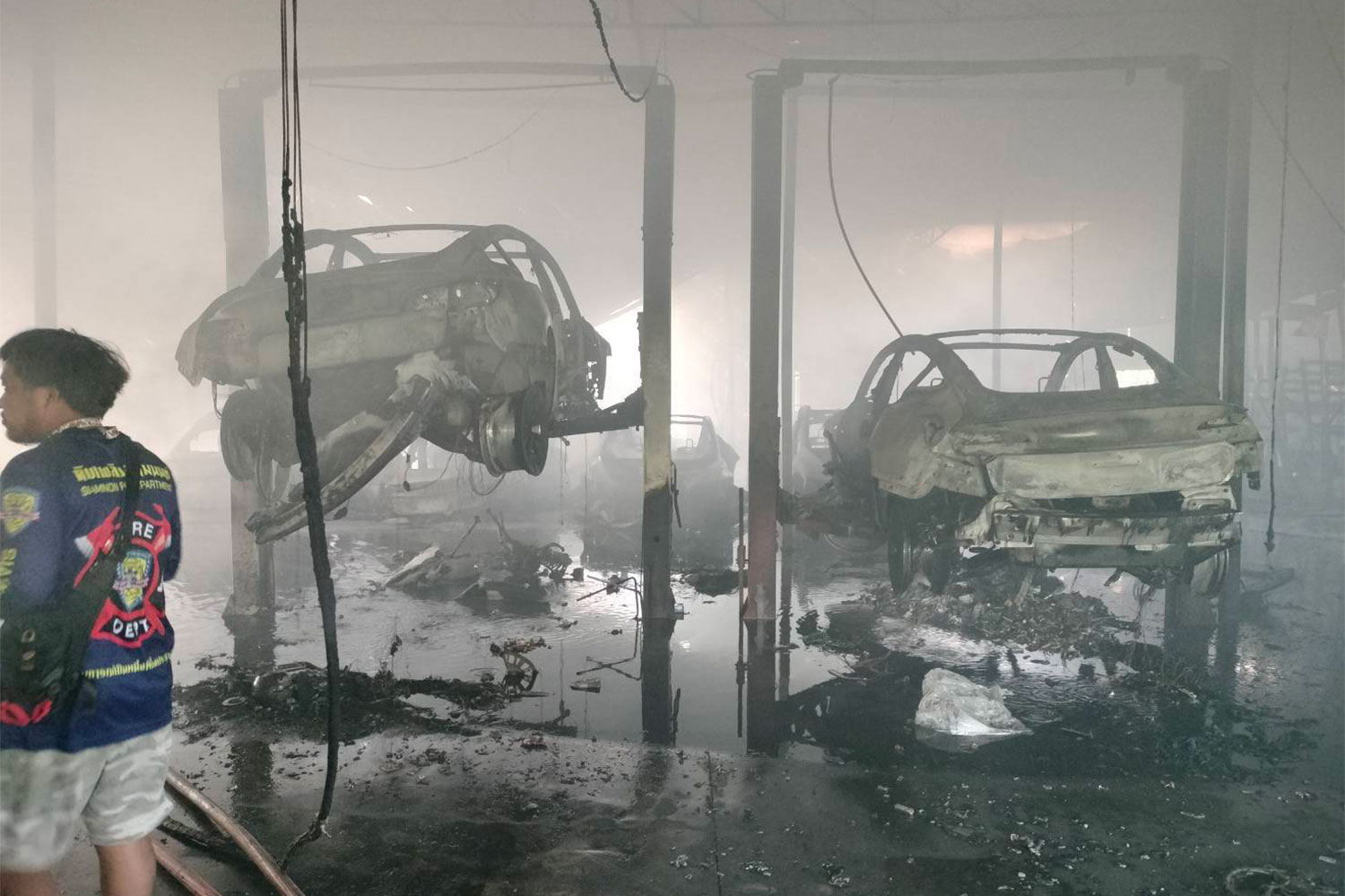 Two luxury cars are seen destroyed in the fire-gutted warehouse in Nonthaburi's Pak Kret district. (Photo: FM91 Trafficpro Facebook)