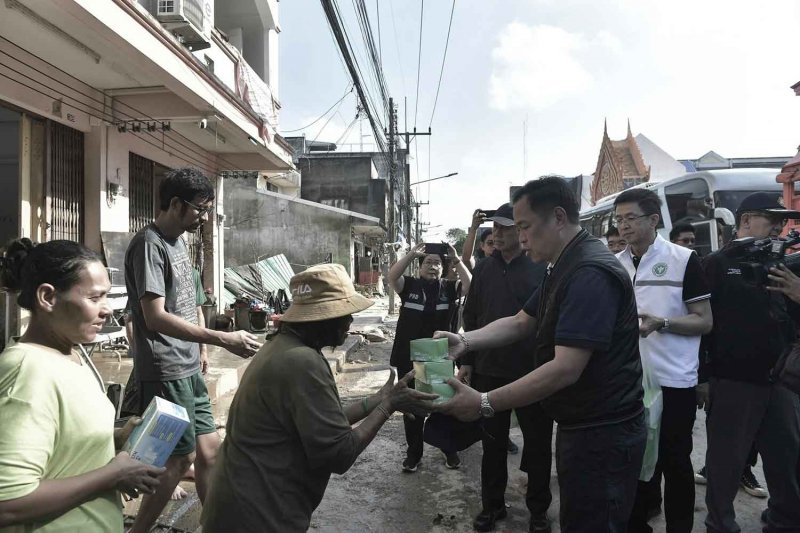 Prime Minister Anutin Charnvirakul hands essential items to flood victims in Hat Yai district, Songkhla, on Sunday. (Photo: Government House)