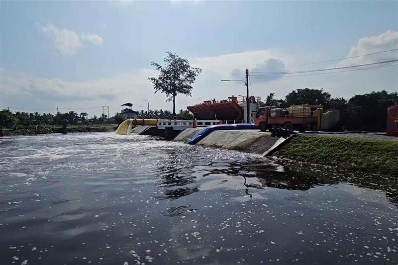 Dark, foul-smelling floodwater remains stagnant along a roadside drainage channel in Pak Phanang district of Nakhon Si Thammarat, where slow drainage has left communities submerged for weeks and caused health risks. (Photo: Nujaree Rakrun)