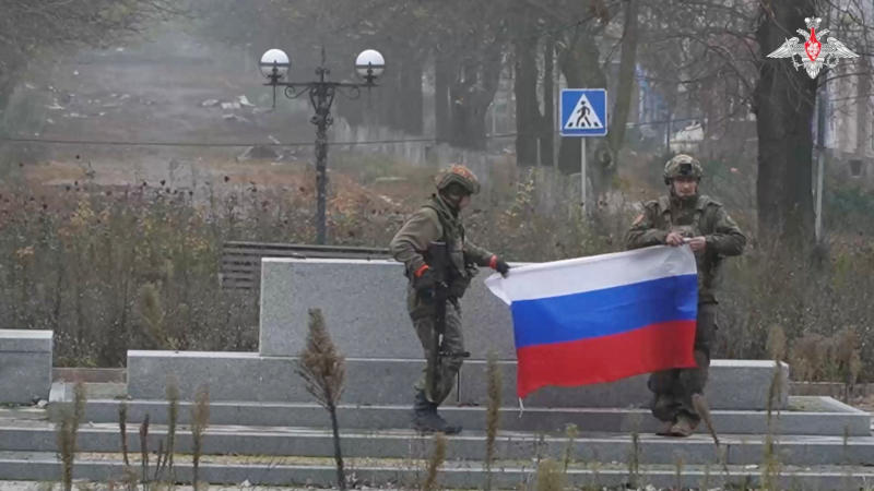 Soldiers hold a Russian flag in Pokrovsk, Donetsk Region, Ukraine, in this screengrab from video released on Monday. (Photo via Reuters)