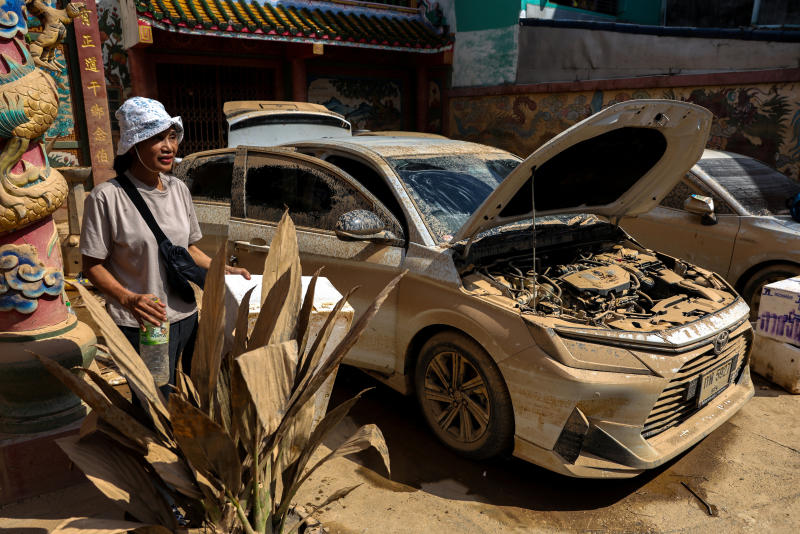 ผู้หญิงคนหนึ่งยืนอยู่ข้างรถของเธอที่เสียหายจากน้ำท่วมครั้งใหญ่ในอำเภอหาดใหญ่ จังหวัดสงขลา เมื่อวันที่ 30 พ.ย. 2568 (ภาพ: รอยเตอร์)