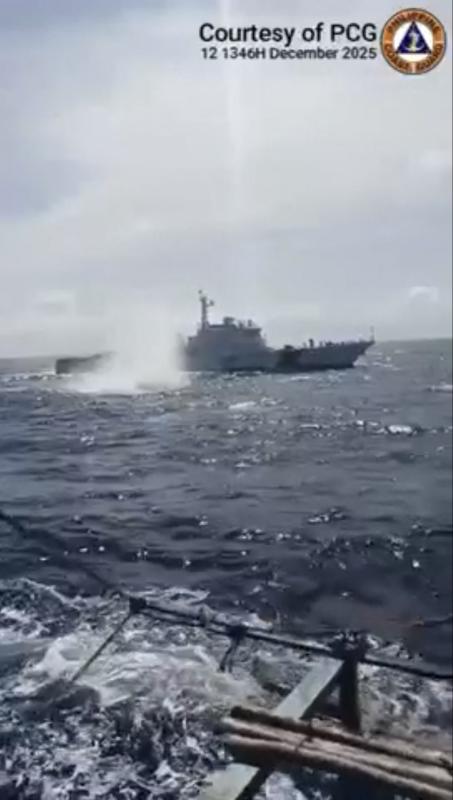 This frame grab from the handout video of the Philippine Coast Guard (PCG) taken and received on December 13, 2025, shows China Coast Guard deploying water cannon towards a Philippine fishing boat near Sabina Shoal in the South China Sea.