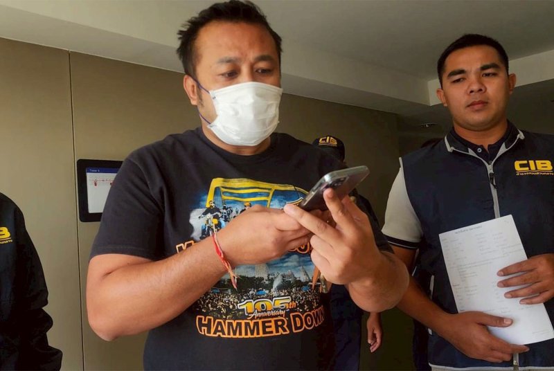 Former Olympic gold medalist Manus Boonjumnong, centre, is arrested for lottery quota fraud in front of a condominium room in Nonthaburi on Friday morning. (Photo supplied/Wassayos Ngamkham)
