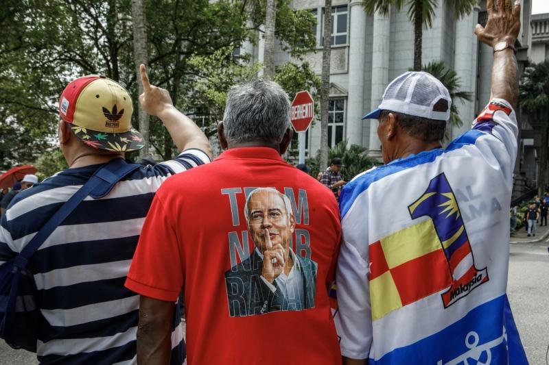 周五，前总理纳吉布·拉扎克的支持者在马来西亚普特拉贾亚的马来西亚上诉法院和联邦法院外等待他对腐败和洗钱指控的判决。 （照片：彭博社）