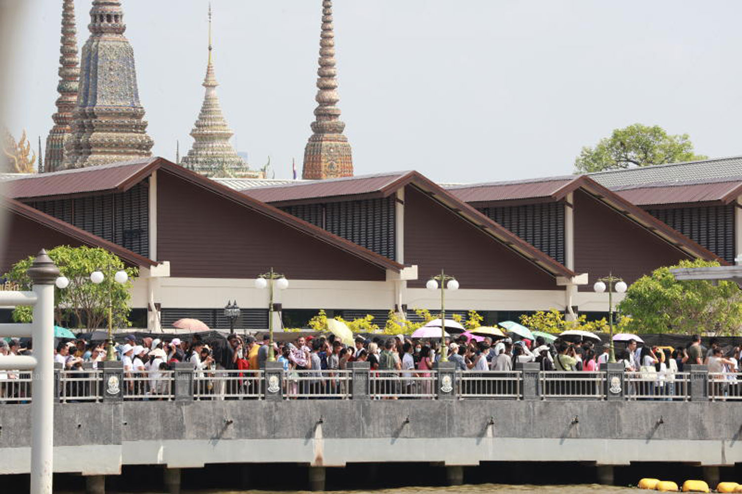 Thai and international travellers line up at Tha Tien Pier on Thursday to board a boat boat to Wat Arun on the other side of the Chao Phraya River. ( Photo: Apichart Jinakul )