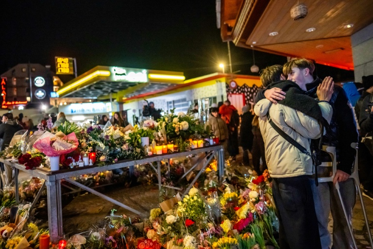 An injured survivor greets a friend next to a makeshift memorial near the site of the New Year’s fire in Crans-Montana, Switzerland. (Photo: AFP)