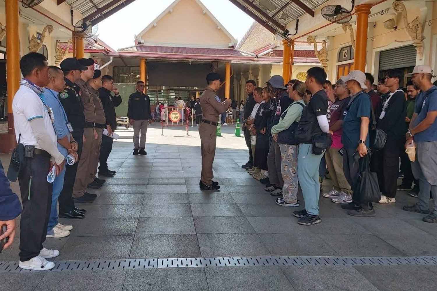 A police officer gives a manner training lesson to photographers at Wat Arun on the undated photo from the temple management.