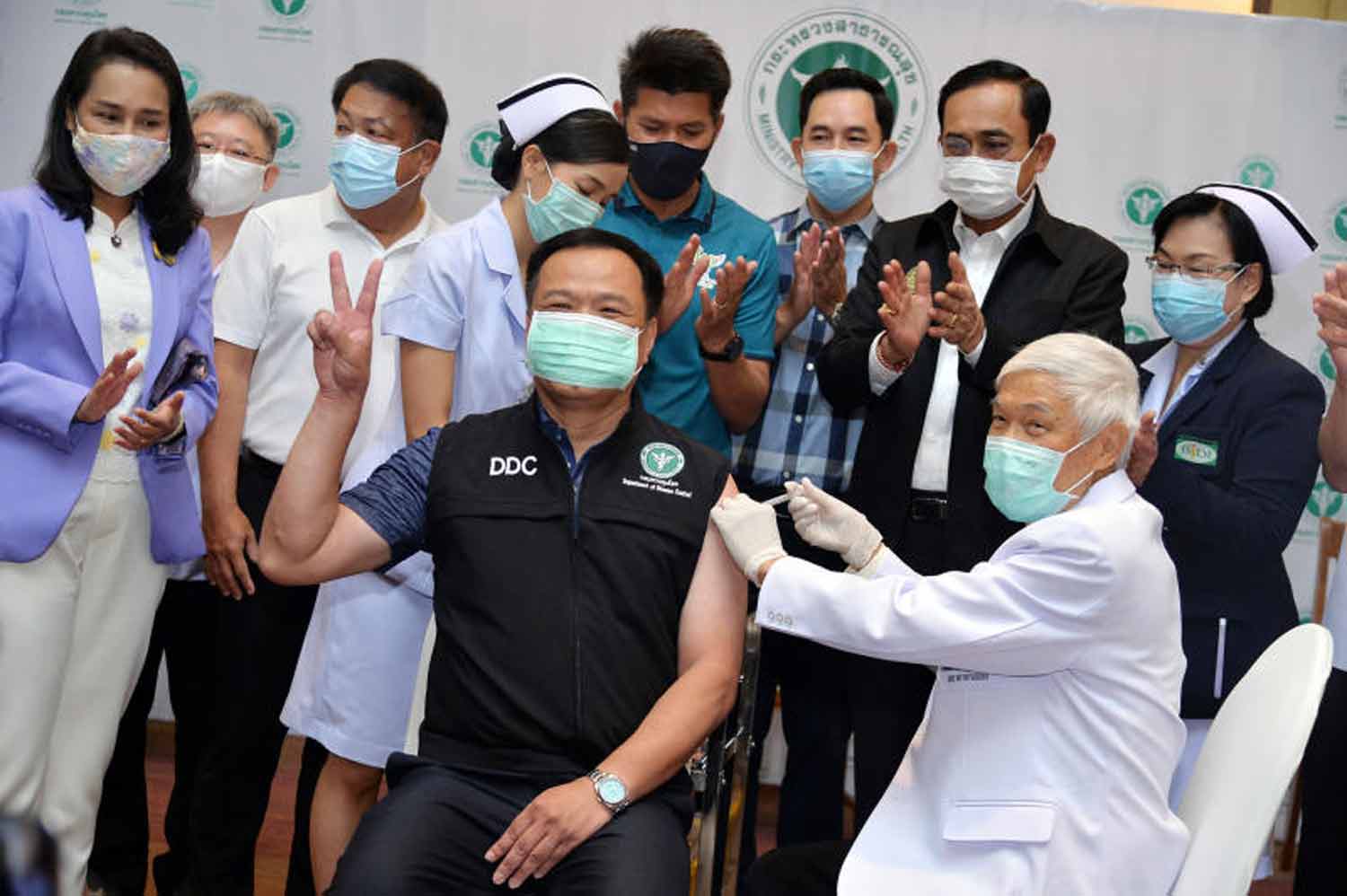 Prof Dr Yong Poovorawan, front right, administers a Covid jab to then Public Health Minister Anutin Charnvirakul at Bamrasnaradura Infectious Diseases Institute in Nonthaburi on Feb 28, 2021. Government House