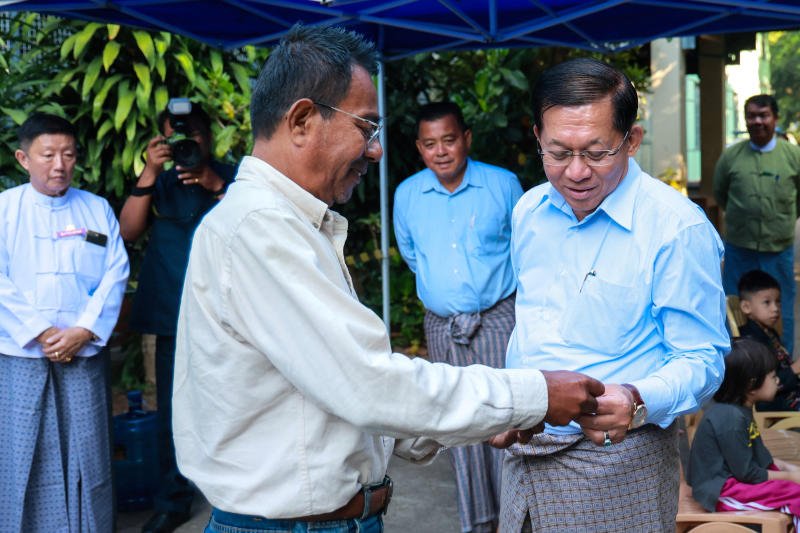 Myanmar's junta chief Min Aung Hlaing speaks to a man outside a polling station during the second phase of the general election, in Yangon on Sunday, Jan 11, 2026. (Photo: Reiuters/stringer)