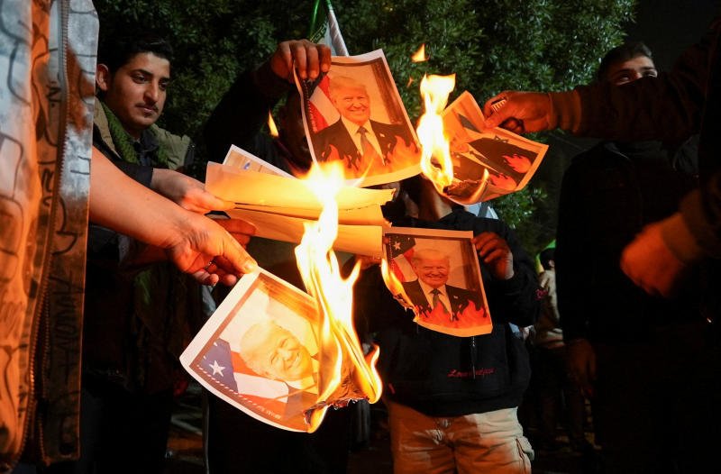 Supporters of Iraqi Shi'ite armed groups burn images of US President Donald Trump and Israeli Prime Minister Benjamin Netanyahu, during a rally in solidarity with Iran's government in Tehran, outside the Iranian consulate in Basra, Iraq, on Tuesday. (Photo: Reuters)