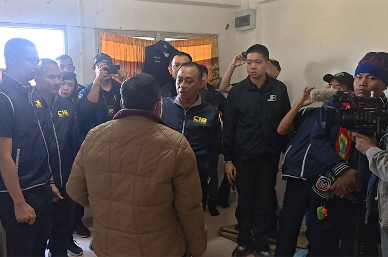 Pol Maj Gen Jruykiat Pankaeo (centre), deputy commissioner of the Central Investigation Bureau (CIB), talks to one of the six officials accused of falsifying documents to grant Thai citizenship to foreigners. (Photo supplied/Wassayos Ngamkham)