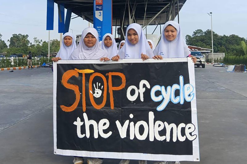 Students take part in a protest on Jan 15 against the recent outbreak of violence in the deep South, at one of the eleven PTT petrol stations that were targeted by bombers, in Cho Airong district of Narathiwat. (Photo: Waedao Harai)