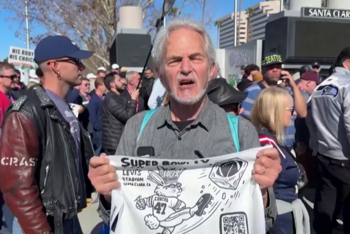 Activists distribute ‘ICE OUT’ towels at the Super Bowl