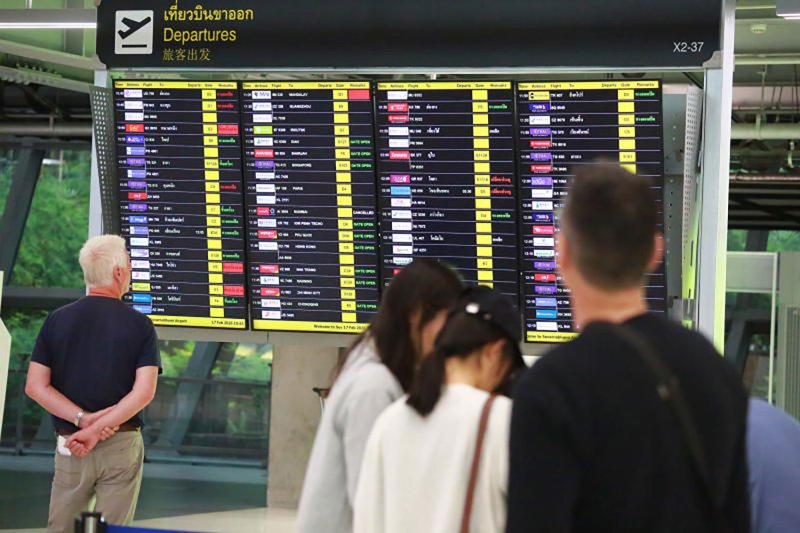 On Tuesday, incoming travelers to the Suvarnabhumi Airport examine the flight departure display. ( Photo: Bangkok Post )