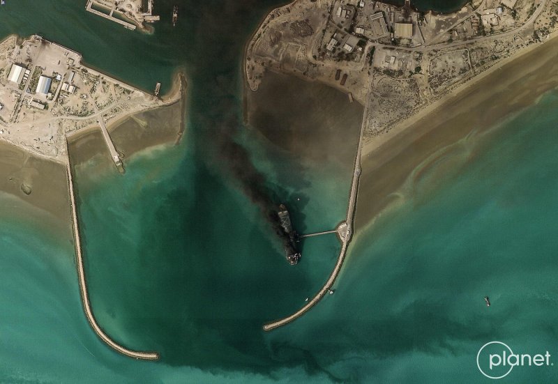 A satellite image taken on March 2, 2026 shows smoke billowing from a vessel following an explosion from the port of Bandar Abbas along the strait of Hormuz. (Photo by 2026 Planet Labs PBC via AFP)
