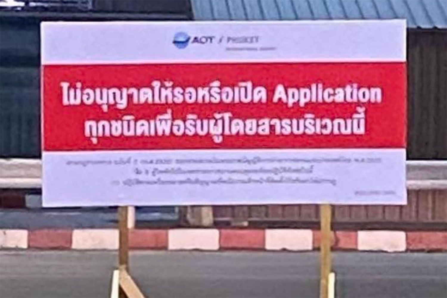The sign displays a Thai message, translated as: “Waiting or opening any application to pick up passengers in this area is not permitted.” (Photo: Phuket Info Center)