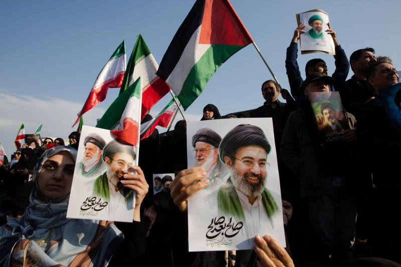 A crowd, holding images of the two, gathers to celebrate Mojtaba Khamenei, the son of the recently killed supreme leader Ayatollah Ali Khamenei, as his father's successor at Enghelab Square in Tehran, Iran, on Monday. (Photo: New York Times)