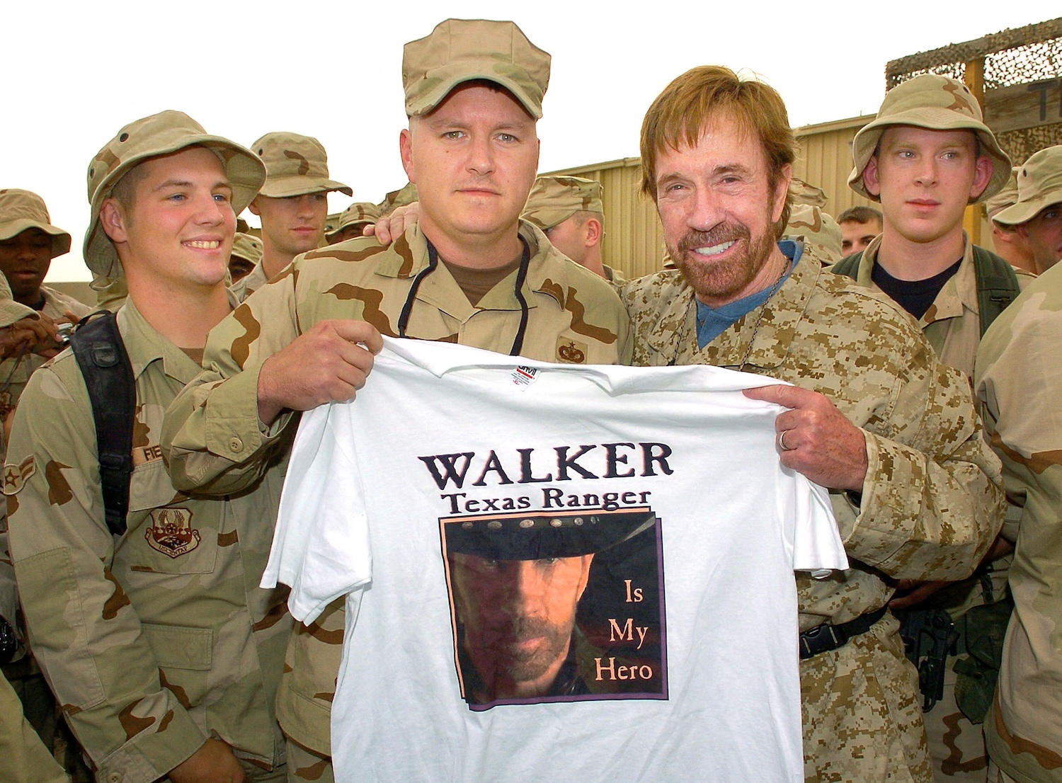 Actor Chuck Norris holds up a T-shirt presented during a meet-the-troops stop at Ali Al Saleem Air Base in Kuwait on Oct 29, 2006. (Photo: USO via Reuters)