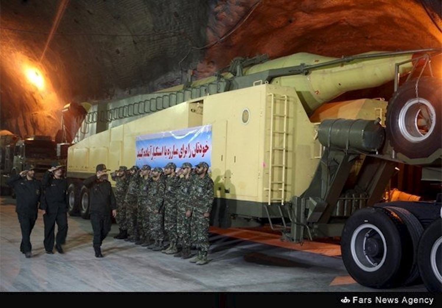 In a rare view of one of Iran&rsquo;s underground military facilities, members of the Islamic Revolutionary Guard Corps Aerospace Force salute in front of a missile launcher in an undisclosed location in 2015. (Photo: Fars News Agency via Reuters)