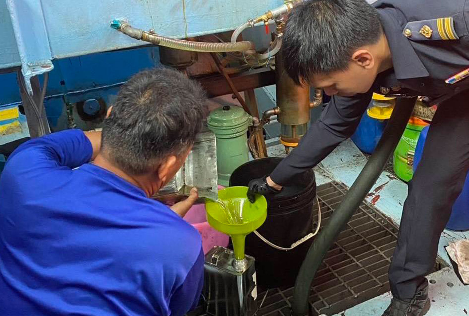 An excise official and a navy officer collect sameple of fuel from the vessel for lab testing. (Photo: Excise Department)