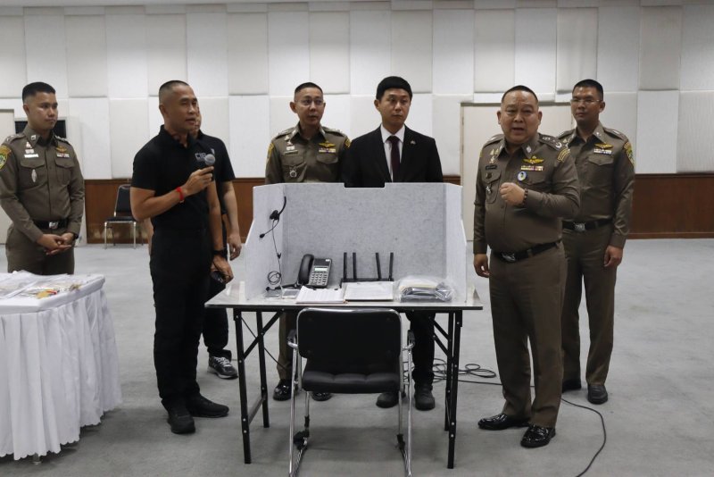 Police accompanied by a South Korean embassy official on Monday display one of the workstations, with equipment, found at the house used by the South Korean scam gang arrested in Bangkok on Sunday. (Photo: Central Investigation Bureau)