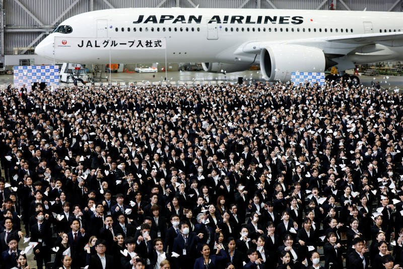 Newly hired employees of Japan Airlines (JAL) group fly paper planes during the company group's initiation ceremony at a hangar of Haneda Airport in Tokyo, Japan, on Wednesday. (Photo: Reuters)
