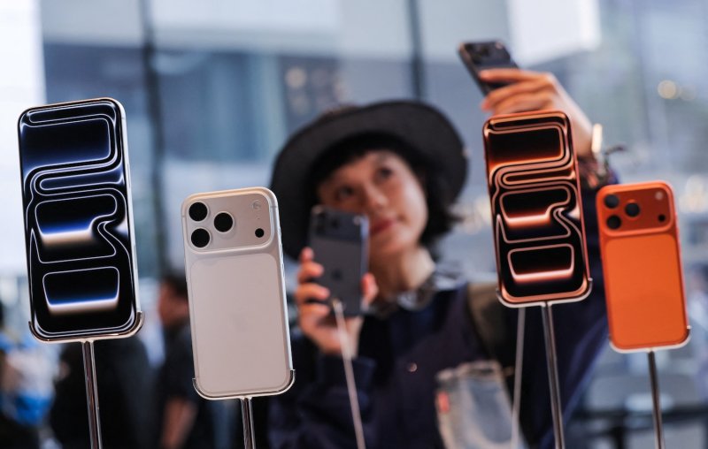 A woman takes a selfie with iPhones inside the Apple store in Beijing. (Photo: Reuters)