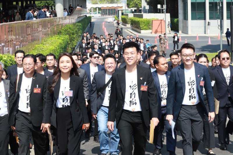 People’s Party MPs arrive at parliament on March 9 to formally register as members of the 27th House of Representatives while wearing T-shirts printed with “prachachon” (people) in Thai beneath their jackets. (Photo: Apichart Jinakul)
