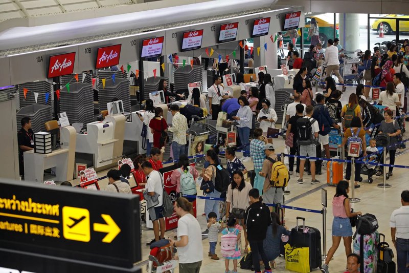 People queue at a check-in counter at Don Mueang airport in Bangkok during Songkran in 2019. (Bangkok Post file photo)