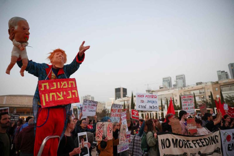 A demonstrator wears a mask depicting U.S. President Donald Trump while holding a puppet of a baby with a mask depicting Israeli Prime Minister Benjamin Netanyahu during an anti-war protest calling for an end to the U.S.-Israel conflict with Iran, in Tel Aviv, Israel, April 4, 2026. REUTERS