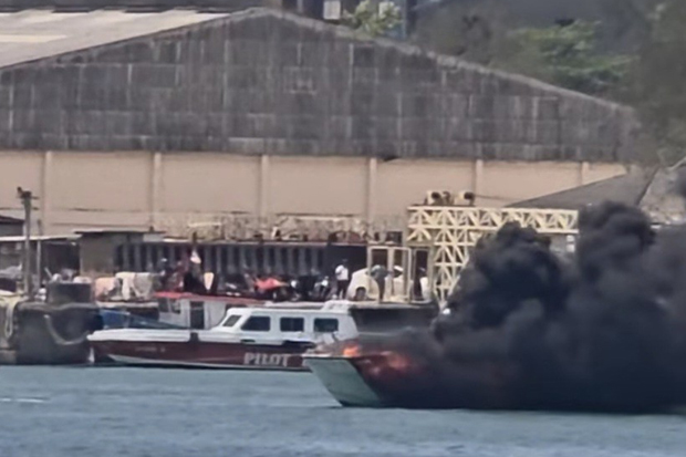 A fireboat extinguishes the blaze on the burning speedboat after it was towed from a jetty in Phuket on Monday. Five people were injured. (Photo: Achadthaya Chuenniran)