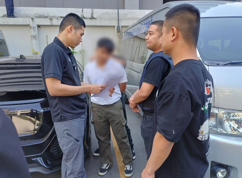Police apprehend one of eight suspects during coordinated raids across seven provinces on Monday in connection with a 55‑million‑baht call‑centre scam and money‑laundering network involving mule bank accounts. (Photo supplied/Wassayos Ngamkham)