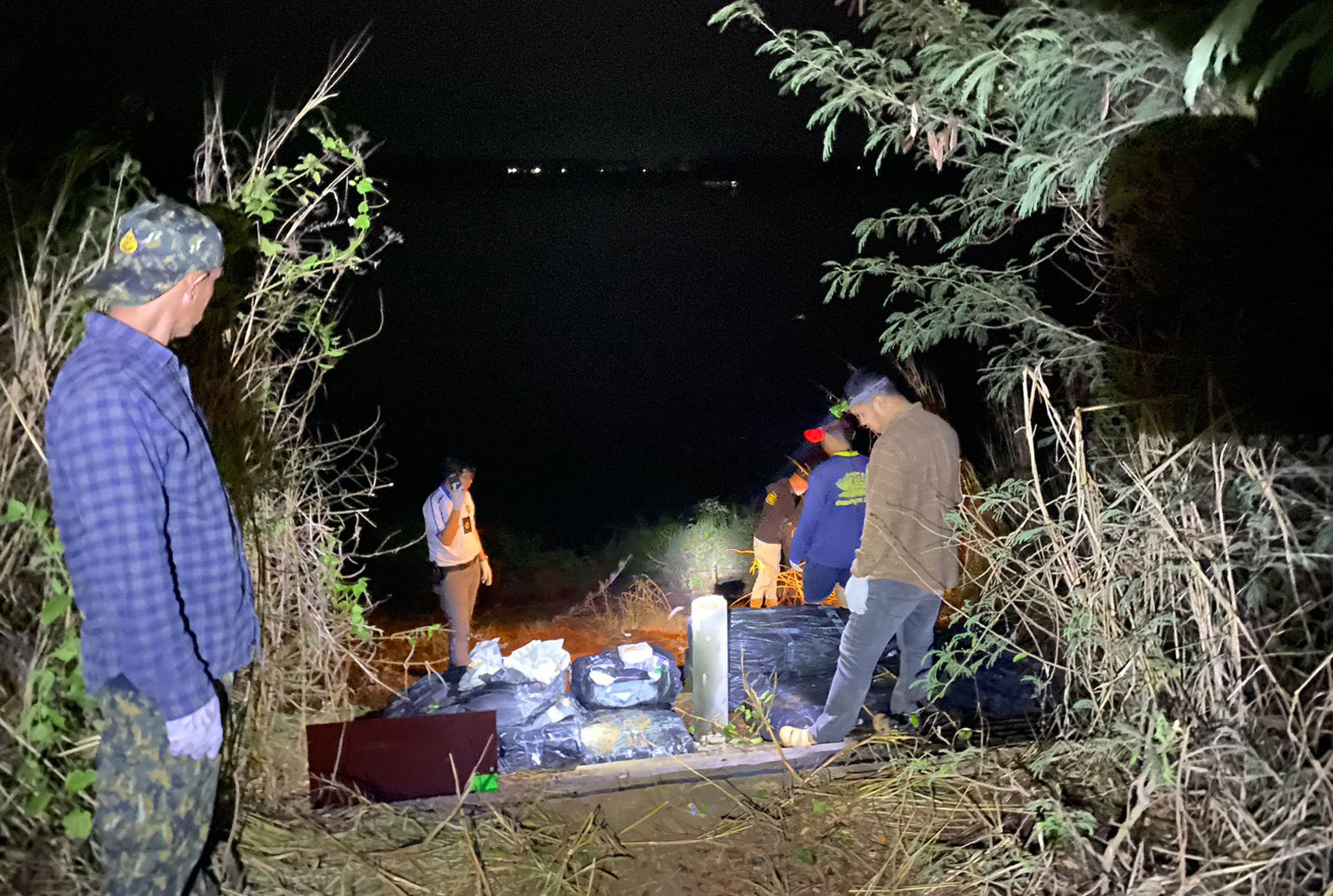 Local officials and Mekong Riverine security forces find 12 sacks of crystal methamphetamine abandoned along the riverbank in Tha Uthen district of Nakhon Phanom province during a late-night patrol. (Photo: Pattanapong Sripiachai)