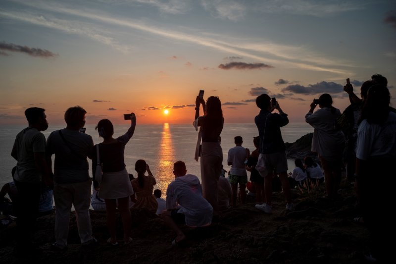 Local residents and tourists admire a sunset from Phromthep Cape on the southwestern tip of Phuket. (Photo: Reuters)