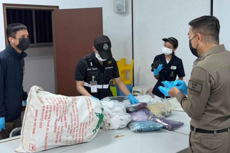 Police unpack Thai silk blouses, later found to have packs of heroin sewn inside them, from sacks at the Vichit police station in Muang district of Phuket on Tuesday. (Police photo)
