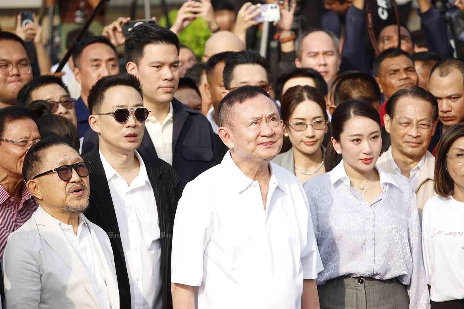 Thaksin listens to the national anthem.