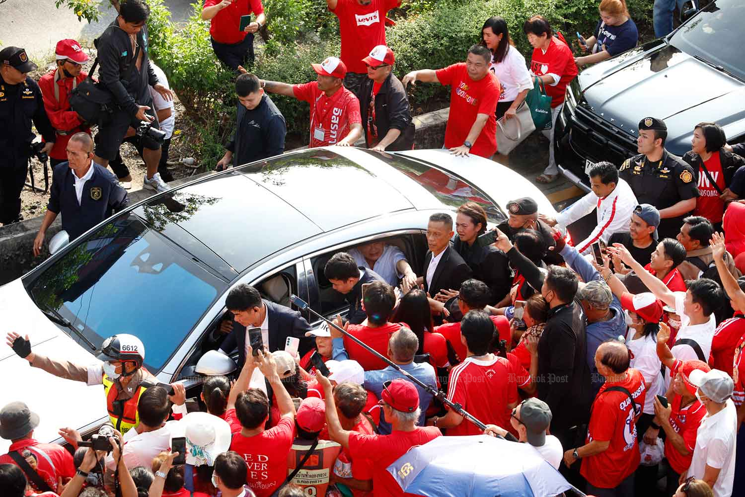 Thaksin in white shirt leaves the prison on the back seat of his luxury car on Monday morning.